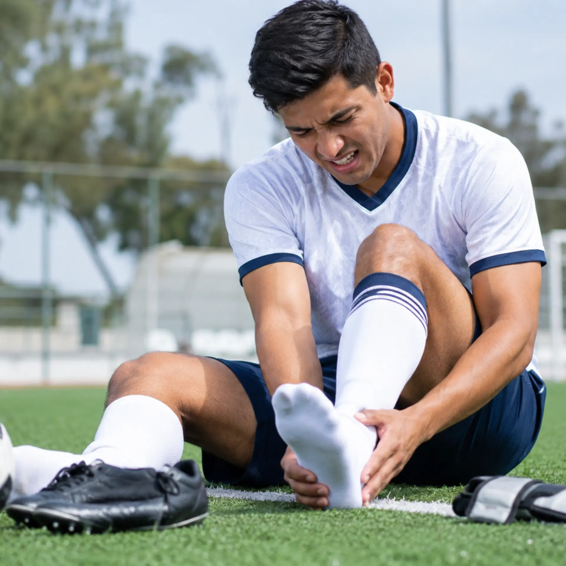Soccer player holding an injured ankle